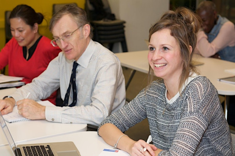 woman smiling sitting next to man and woman